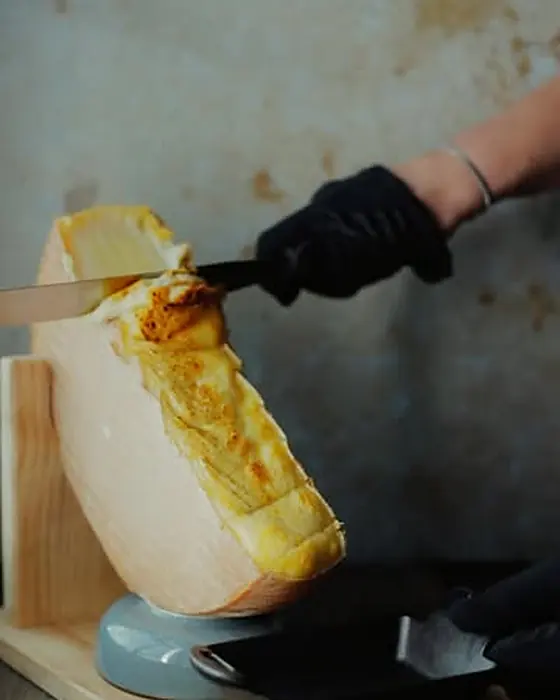 Raclette zeskrobywane z krążka sera